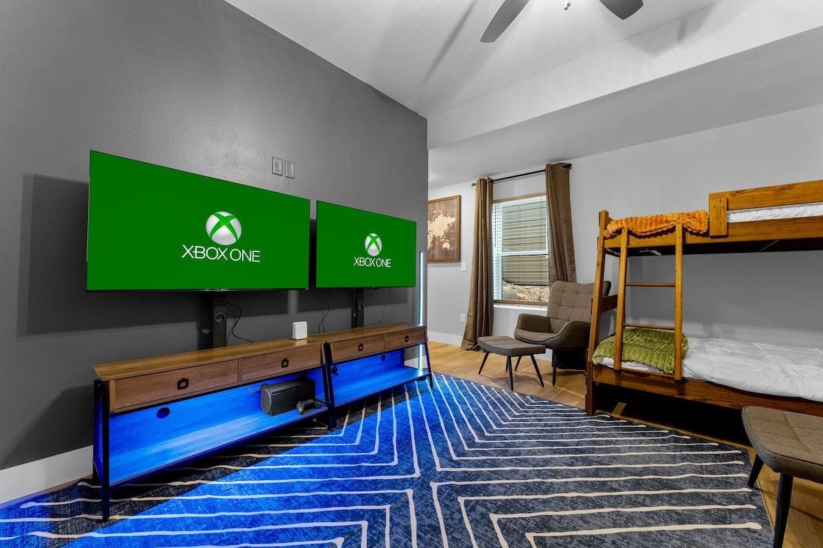 The Bunk Room isn't just for sleeping: Gaming paradise with dual TVs, retro consoles, and vibrant LED lights for endless fun!